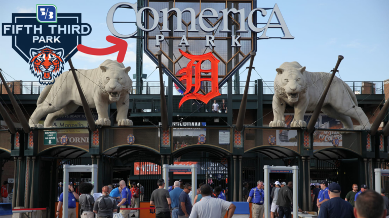 Entrance area of Comerica Park with two white tiger statues, large signage, and fans gathered below.